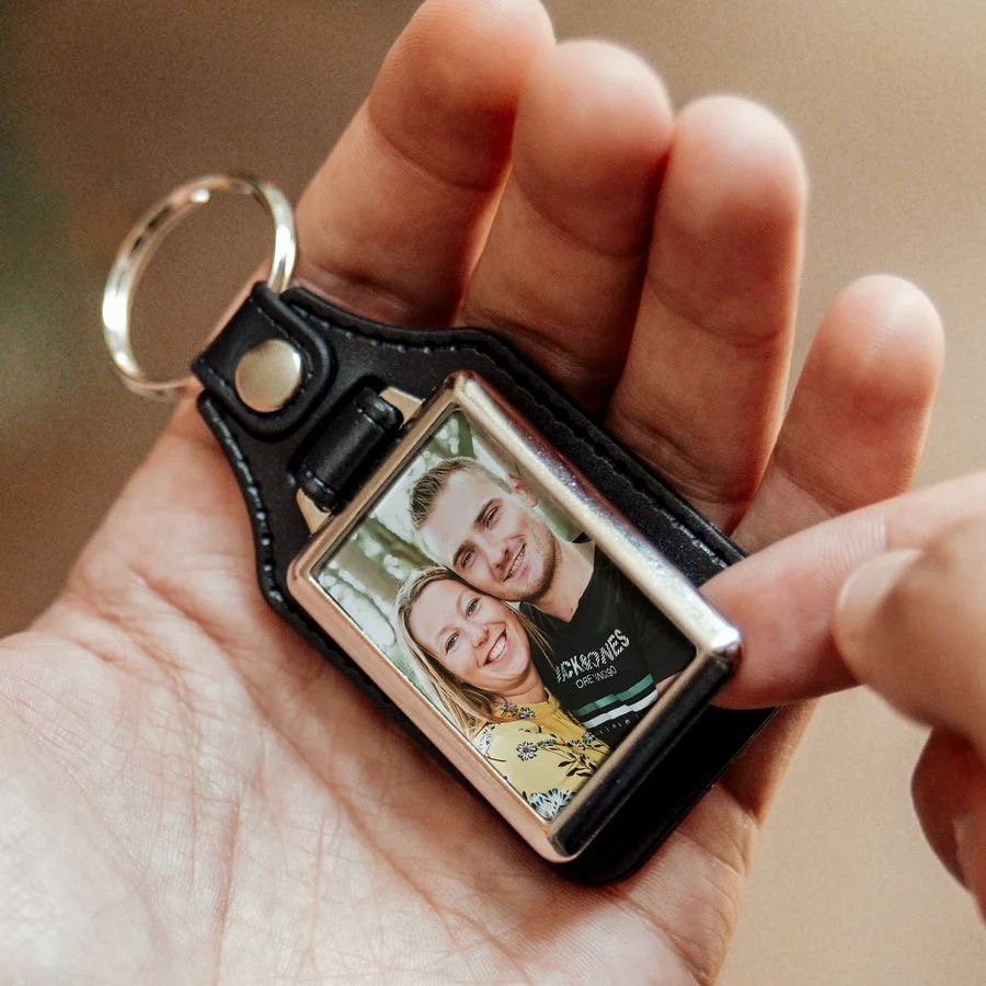 Porte-clés en cuir avec photo d’un couple, tenu en main